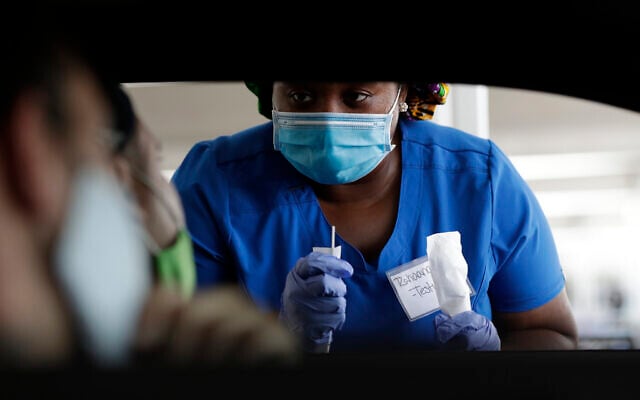 Healthcare worker Rahaana Smith instructs passengers how to provide their coronavirus test sample, on Friday, July 24, 2020, at a drive-thru coronavirus testing site in Miami. (AP/Wilfredo Lee) Healthcare worker Rahaana Smith instructs passengers how to provide their coronavirus test sample, on Friday, July 24, 2020, at a drive-thru coronavirus testing site in Miami. (AP/Wilfredo Lee)