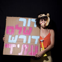 Kalanit Sharon, 31, poses for a photo during a protest against Prime Minister Benjamin Netanyahu, outside his residence in Jerusalem, July 23, 2020. Hebrew on her sign reads 'An entire generation demands a future.' (AP Photo/Oded Balilty) Kalanit Sharon, 31, poses for a photo during a protest against Prime Minister Benjamin Netanyahu, outside his residence in Jerusalem, July 23, 2020. Hebrew on her sign reads 'An entire generation demands a future.' (AP Photo/Oded Balilty)