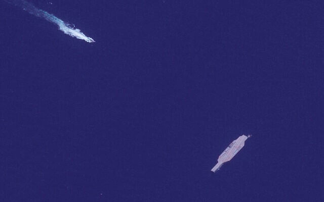 In this July 26, 2020, satellite photo provided on July 27, by Maxar Technologies, an Iranian fast boat, top left, approaches a mockup aircraft carrier built by Iran in the Strait of Hormuz. (Maxar Technologies via AP) In this July 26, 2020, satellite photo provided on July 27, by Maxar Technologies, an Iranian fast boat, top left, approaches a mockup aircraft carrier built by Iran in the Strait of Hormuz. (Maxar Technologies via AP)