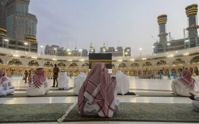 Pilgrims pray around the Kaaba, the square structure in the Great Mosque, toward which believers turn when praying, in Mecca, Saudi Arabia, July 26, 2020. (Saudi Ministry of Media via AP)