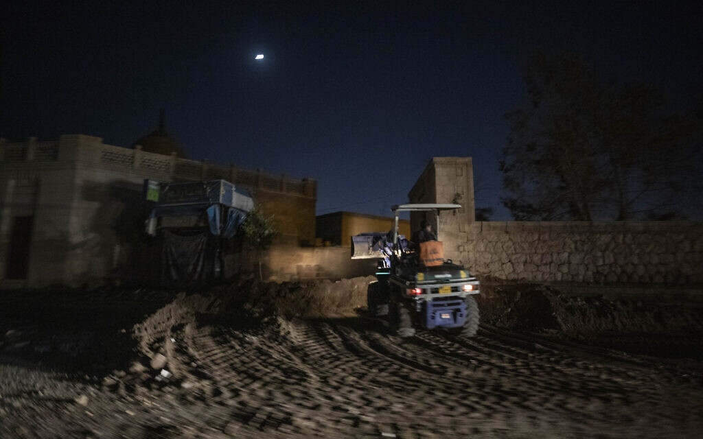 A bulldozer knocks down walls and tombs amid work to clear way for a new highway running through the historic Northern Cemetery in Cairo, Egypt, Sunday, July 26, 2020. (AP Photo/Nariman El-Mofty)