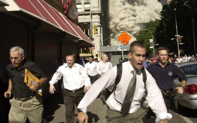 In this September 11, 2001, photo, people, including Stephen Cooper on the far left, run from the collapse of one of the twin towers at the World Trade Center in New York. (AP Photo/Suzanne Plunkett) In this September 11, 2001, photo, people, including Stephen Cooper on the far left, run from the collapse of one of the twin towers at the World Trade Center in New York. (AP Photo/Suzanne Plunkett)