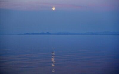 The moon rises over the coast of Alaska as the Finnish icebreaker MSV Nordica sails along the international date line through the Bering Strait, July 14, 2017. (AP Photo/David Goldman)