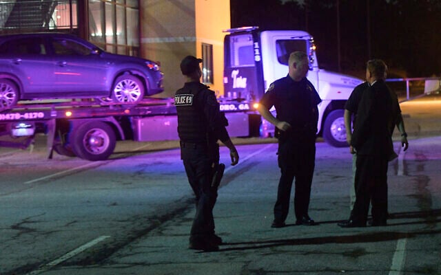 Illustrative: Law enforcement officers talk as a car is towed away in the Mt. Zion High School parking lot as part of an investigation into a shooting on May 18, 2018, near Atlanta, Georgia. (AP/John Amis) Illustrative: Law enforcement officers talk as a car is towed away in the Mt. Zion High School parking lot as part of an investigation into a shooting on May 18, 2018, near Atlanta, Georgia. (AP/John Amis)