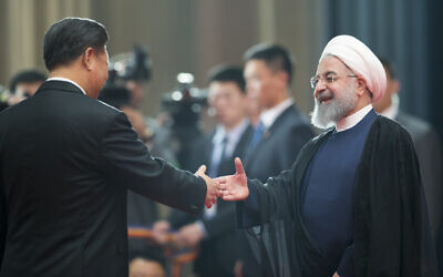 Chinese President Xi Jinping, left, greets Iranian President Hassan Rouhani at the Shanghai Cooperation Organization (SCO) Summit in Qingdao in eastern China's Shandong Province on June 10, 2018. (AP Photo/Alexander Zemlianichenko)