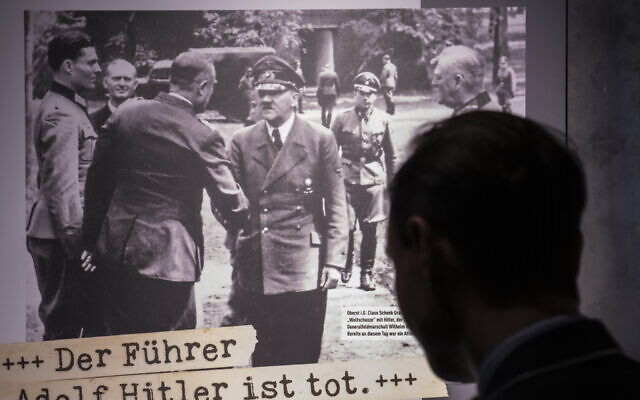 Visitors stands in front of a poster during a press preview of the special exhibition 'The Fuehrer Adolf Hitler is dead - Attempted Assassination and coup d'etat on 20 July 1944.' by the Bundeswehr Museum of Military History in Dresden, Germany, Wednesday, July 3, 2019.  (AP Photo/Jens Meyer)