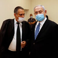 Prime Minister Benjamin Netanyahu (R) talks with attorney Micha Fettman (L) inside the court room, as his corruption trial opens at the Jerusalem District Court, May 24, 2020. (Ronen Zvulun/ Pool Photo via AP)