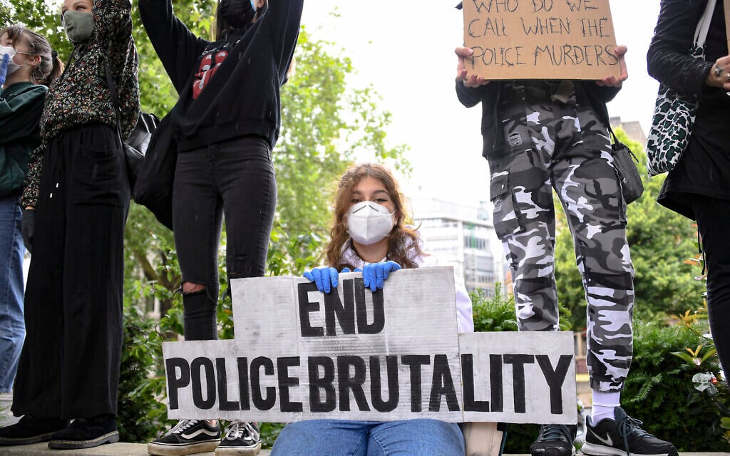A girl holds a placard during a Black Lives Matter rally in Parliament Square in London, Saturday, June 6, 2020, as people protest against the killing of George Floyd by police officers in Minneapolis, Minnesota. (AP Photo/Alberto Pezzali)