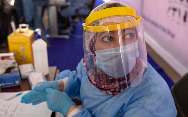 A health worker wearing protective gear prepares to take swab samples from people lining up in their cars to test for the coronavirus at a drive-through COVID-19 screening center at Ain Shams University in Cairo, Egypt on June 17, 2020. (AP Photo/Nariman El-Mofty) A health worker wearing protective gear prepares to take swab samples from people lining up in their cars to test for the coronavirus at a drive-through COVID-19 screening center at Ain Shams University in Cairo, Egypt on June 17, 2020. (AP Photo/Nariman El-Mofty)