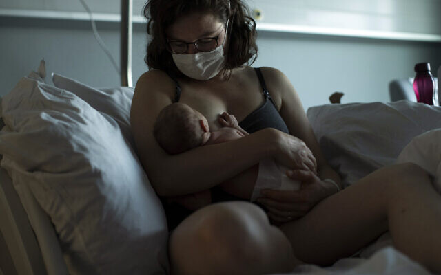 Illustrative: Marie L'Hoest, wearing a face mask to protect against the spread of coronavirus, breastfeeds her newborn daughter Anouk at the MontLegia CHC hospital in Liege, Belgium, Friday, June 26, 2020.(AP Photo/Francisco Seco) Illustrative: Marie L'Hoest, wearing a face mask to protect against the spread of coronavirus, breastfeeds her newborn daughter Anouk at the MontLegia CHC hospital in Liege, Belgium, Friday, June 26, 2020.(AP Photo/Francisco Seco)