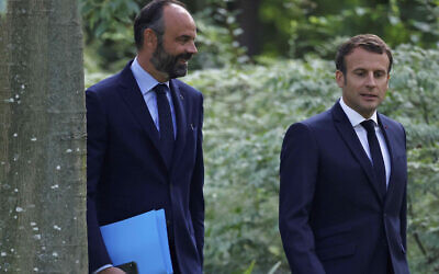 French President Emmanuel Macron, right, and French Prime Minister Edouard Philippe arrive for a meeting with members of the Citizens' Convention on Climate to discuss over environment proposals at the Elysee Palace in Paris on June 29, 2020. (Christian Hartmann/Pool via AP)