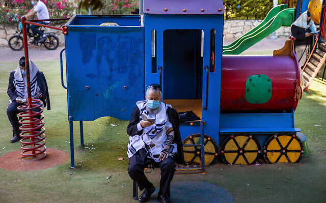 Ultra-Orthodox Jews pray at a playground next to their homes in Bnei Brak, Israel, Thursday, July 2, 2020. (AP/Oded Balilty) Ultra-Orthodox Jews pray at a playground next to their homes in Bnei Brak, Israel, Thursday, July 2, 2020. (AP/Oded Balilty)