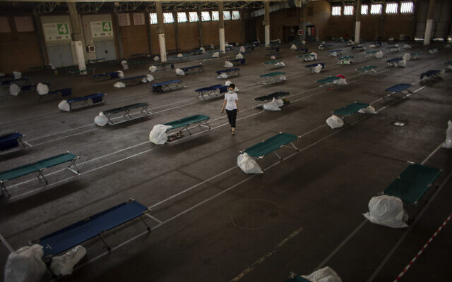 A local worker walks along an exhibition center turned into a temporary seasonal workers' shelter in Lleida, Spain, on July 2, 2020 (AP Photo/Emilio Morenatti) A local worker walks along an exhibition center turned into a temporary seasonal workers' shelter in Lleida, Spain, on July 2, 2020 (AP Photo/Emilio Morenatti)