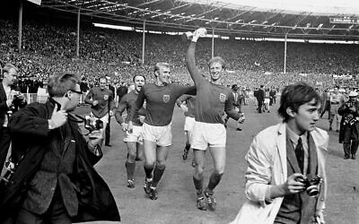 In this July 30, 1966 file photo England's Jack Charlton, right, holds the Jules Rimet trophy aloft as he parades it around Wembley with teammate Bobby Moore following their 4-2 win over West Germany (PA via AP)