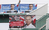 A man walks by campaign posters showing two contenders in Poland's presidential election runoff, conservative incumbent President Andrzej Duda and his rival, liberal Warsaw Mayor Rafal Trzaskowski, top, in Warsaw, Poland, July 11, 2020. (AP Photo/Czarek Sokolowski)