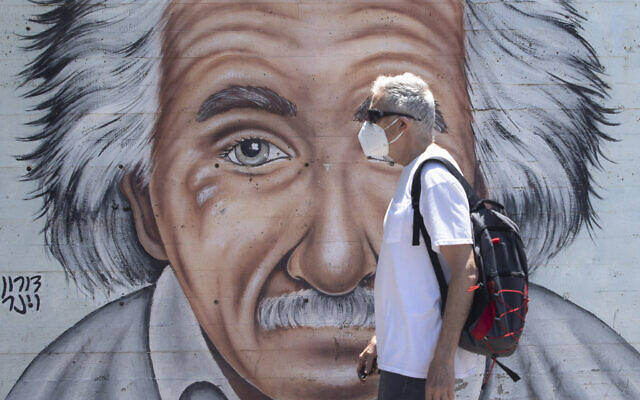 An Israeli man wearing a mask to curb the spread of the coronavirus walks past a mural showing Albert Einstein in Tel Aviv, July 15, 2020. (AP/Sebastian Scheiner) An Israeli man wearing a mask to curb the spread of the coronavirus walks past a mural showing Albert Einstein in Tel Aviv, July 15, 2020. (AP/Sebastian Scheiner)