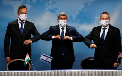 Israeli Foreign Minister Gabi Ashkenazi, center, his Hungarian counterpart Peter Peter Szijjártó, left and Israeli Minister of Science and Technology Izhar Shay, right, give elbow bump greetings during their meeting, in Jerusalem, July 20, 2020. (Ronen Zvulun/Pool via AP) Israeli Foreign Minister Gabi Ashkenazi, center, his Hungarian counterpart Peter Peter Szijjártó, left and Israeli Minister of Science and Technology Izhar Shay, right, give elbow bump greetings during their meeting, in Jerusalem, July 20, 2020. (Ronen Zvulun/Pool via AP)