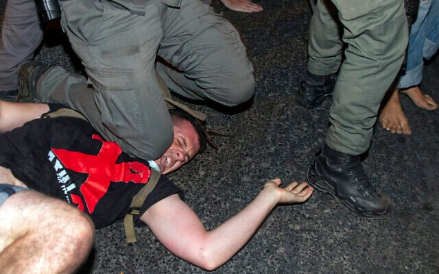 An Israeli police officer puts his knee on a demonstrator to make an arrest during a protest against Prime Minister Benjamin Netanyahu outside his residence in Jerusalem, early Wednesday, July 22, 2020. (AP Photo/Ariel Schalit) An Israeli police officer puts his knee on a demonstrator to make an arrest during a protest against Prime Minister Benjamin Netanyahu outside his residence in Jerusalem, early Wednesday, July 22, 2020. (AP Photo/Ariel Schalit)