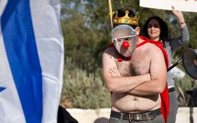 An activist wears a mask bearing a portrait of Prime Minister Benjamin Netanyahu on March 27, 2016.  (AP/Ariel Schalit)