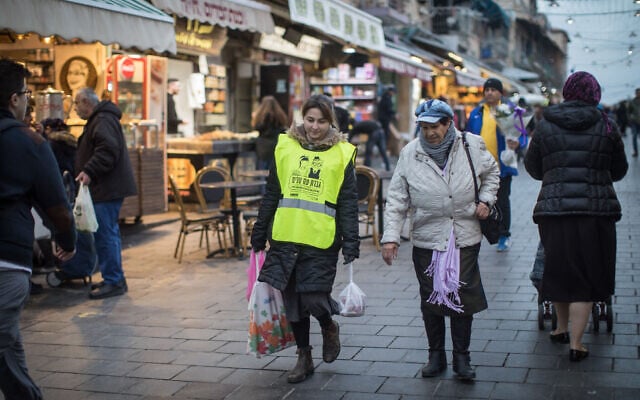 A young woman helps an elderly lady with her grocery bags at the Mahane Yehuda Market in Jerusalem, February 14, 2019. (Hadas Parush/Flash90) A young woman helps an elderly lady with her grocery bags at the Mahane Yehuda Market in Jerusalem, February 14, 2019. (Hadas Parush/Flash90)