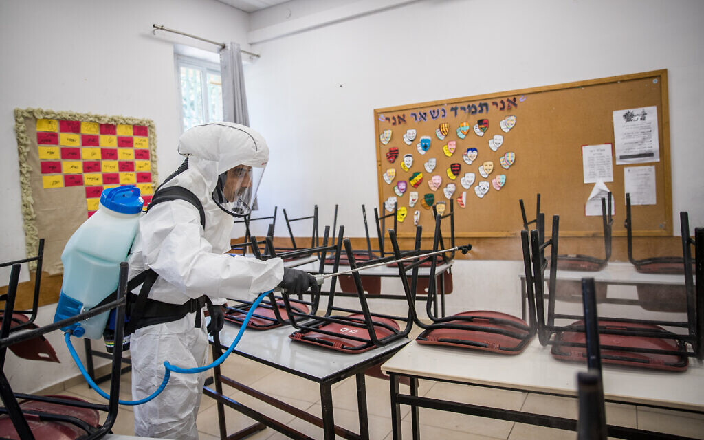 Cleaning workers disinfect a classroom at the Gymnasia Rehavia high school in Jerusalem on June 3, 2020. (Yonatan Sindel/ Flash90) Cleaning workers disinfect a classroom at the Gymnasia Rehavia high school in Jerusalem on June 3, 2020. (Yonatan Sindel/ Flash90)