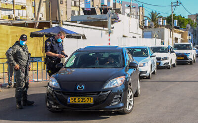 Police officers guard the entrance to a neighborhood in the city of Lod, July 2, 2020, during a closure (Yossi Aloni/Flash90)