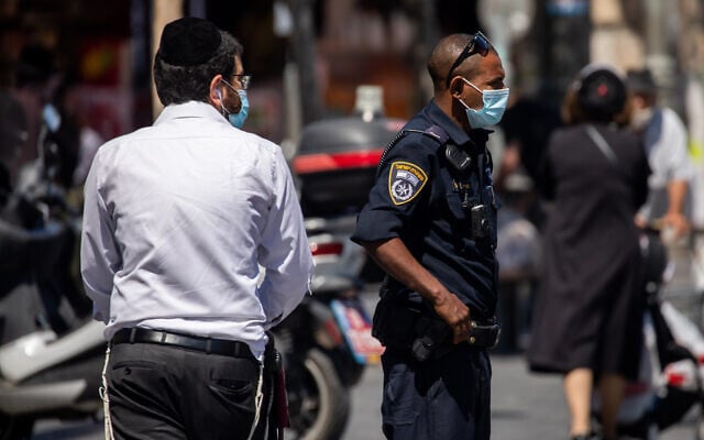 Police officers patrol outside the Mahane Yehuda market in Jerusalem to enforce the emergency regulations, on July 3, 2020. (Yonatan Sindel/Flash90) Police officers patrol outside the Mahane Yehuda market in Jerusalem to enforce the emergency regulations, on July 3, 2020. (Yonatan Sindel/Flash90)