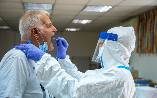 Health care workers take test samples of Israelis to check if they have been infected with the coronavirus, at a Clalilt health center in Lod, on July 05, 2020. (Yossi Aloni/FLASH90) Health care workers take test samples of Israelis to check if they have been infected with the coronavirus, at a Clalilt health center in Lod, on July 05, 2020. (Yossi Aloni/FLASH90)