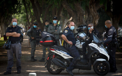 Police stand guard at a protest by self-employed Israelis protesting the lack of financial support from the government, on Rothschild Boulevard in Tel Aviv, July 7, 2020. (Miriam Alster/Flash90)
