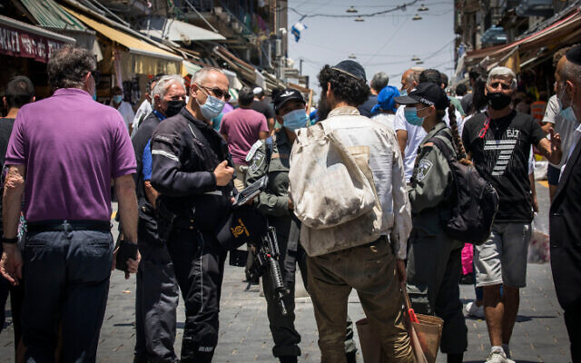 Police and shoppers at the Mahane Yehuda market in Jerusalem on July 7, 2020. (Olivier Fitoussi/Flash90) Police and shoppers at the Mahane Yehuda market in Jerusalem on July 7, 2020. (Olivier Fitoussi/Flash90)