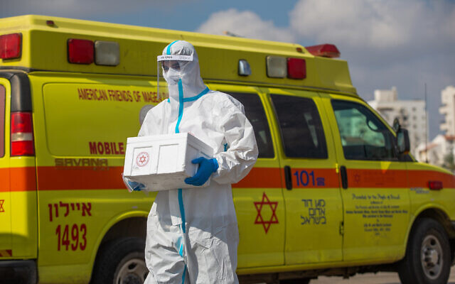 Magen David Adom medical workers test Israelis for the coronavirus at a drive-through site in Lod, on July 10, 2020. (Yossi Aloni/Flash90) Magen David Adom medical workers test Israelis for the coronavirus at a drive-through site in Lod, on July 10, 2020. (Yossi Aloni/Flash90)