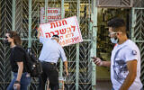A man hangs a 'for rent' sign on a store in Jerusalem on July 12, 2020. (Olivier Fitoussi/Flash90)