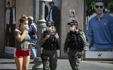 Jerusalem residents wearing face masks for fear of coronavirus  walk on Jaffa Road in the city center of Jerusalem on July 12, 2020. (Olivier Fitoussi/Flash90)