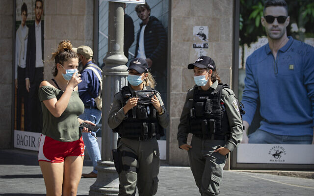 Jerusalem residents wearing face masks for fear of coronavirus walk on Jaffa Road in the city center of Jerusalem on July 12, 2020. (Olivier Fitoussi/Flash90) Jerusalem residents wearing face masks for fear of coronavirus walk on Jaffa Road in the city center of Jerusalem on July 12, 2020. (Olivier Fitoussi/Flash90)