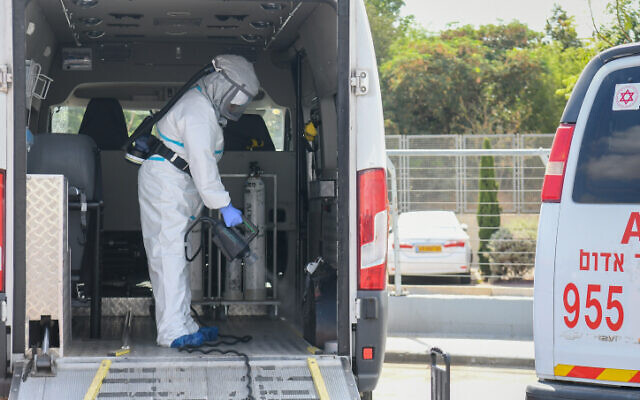 A worker disinfects a car outside the Sheba Medical Center in Ramat Gan on July 13, 2020 (Yossi Zeliger/Flash90) A worker disinfects a car outside the Sheba Medical Center in Ramat Gan on July 13, 2020 (Yossi Zeliger/Flash90)