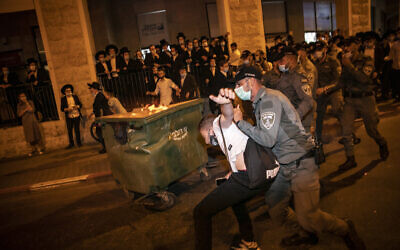 Border Police officers scuffle with ultra-Orthodox Jews during a protest against the closure on the Romema and Kiryat Belz neighborhoods of Jerusalem, on July 13, 2020. (Olivier Fitoussi/Flash90)