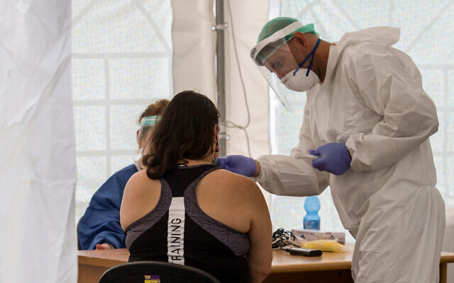 Illustrative: Medical workers test local residents at a temporary site to collect samples for coronavirus, in south Tel Aviv on July 16, 2020.(Flash90) Illustrative: Medical workers test local residents at a temporary site to collect samples for coronavirus, in south Tel Aviv on July 16, 2020.(Flash90)