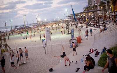 People enjoy the beach in Tel Aviv on July 18, 2020. (Miriam Alster/Flash90)