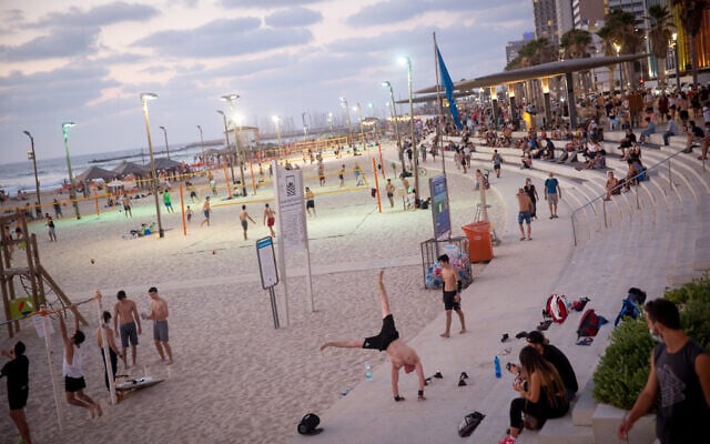 People enjoy the beach in Tel Aviv on July 18, 2020. (Miriam Alster/Flash90) People enjoy the beach in Tel Aviv on July 18, 2020. (Miriam Alster/Flash90)