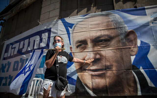 A supporter of Prime Minister Benjamin Netanyahu protests outside the Jerusalem District Court during a hearing in his trial on July 19, 2020 (Yonatan Sindel/Flash90) A supporter of Prime Minister Benjamin Netanyahu protests outside the Jerusalem District Court during a hearing in his trial on July 19, 2020 (Yonatan Sindel/Flash90)