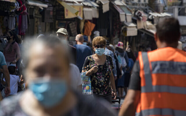 Israelis, wearing face masks to protect from the coronavirus, shop at the Mahane Yehuda market in Jerusalem on July 21, 2020 (Olivier Fitoussi/Flash90) Israelis, wearing face masks to protect from the coronavirus, shop at the Mahane Yehuda market in Jerusalem on July 21, 2020 (Olivier Fitoussi/Flash90)