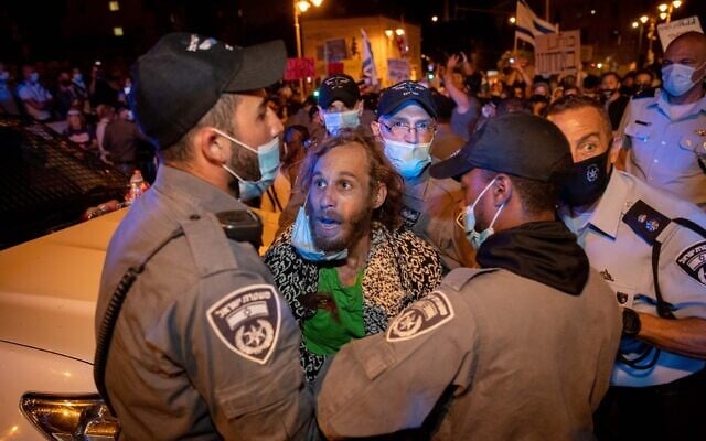Police officers detain a man during a protest against Prime Minister Benjamin Netanyahu outside his official residence in Jerusalem on July 21, 2020. (Yonatan Sindel/Flash90) Police officers detain a man during a protest against Prime Minister Benjamin Netanyahu outside his official residence in Jerusalem on July 21, 2020. (Yonatan Sindel/Flash90)