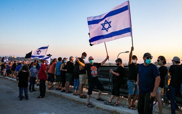 Israelis protest against Prime Minister Benjamin Netanyahu on a bridge in the Jezreel Valley in northern Israel, on July 25, 2020. (Anat Hermony/Flash90) Israelis protest against Prime Minister Benjamin Netanyahu on a bridge in the Jezreel Valley in northern Israel, on July 25, 2020. (Anat Hermony/Flash90)