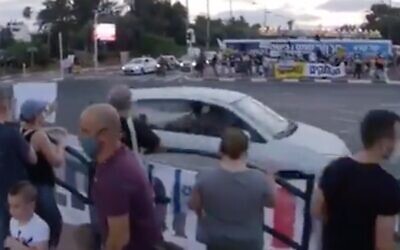 Screen capture from video of a driver allegedly spraying pepper spray from the window of a car at protesters against Prime Minister Benjamin Netanyahu at the Aluf Sadeh Junction, July 25, 2020. (Twitter)