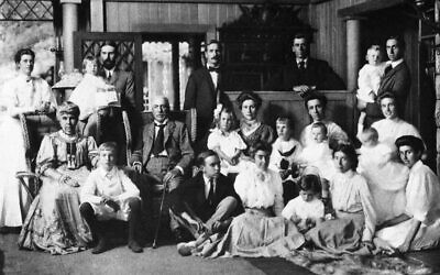 Parents of Graham Stokes (seated, left and center) with their children, children-in-law, and grandchildren at their Adirondack estate in 1907. Graham is standing, hands crossed on counter; Rose Pastor Stokes is on floor, second from right. (Stokes Records, vol. 3, by Anson Phelps Stokes)