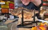 Chef Tal Cohen squirts lemon on the 'Sasha-Biton Fish,' at the Silo restaurant in Holon. (Screen capture: Channel 12)