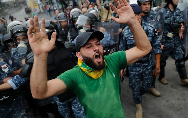 A Hezbollah supporter shouts slogans in front of riot police during a protest against the US near its embassy in Aukar, northeast of Beirut, Lebanon, July 10, 2020. (AP Photo/Hussein Malla) A Hezbollah supporter shouts slogans in front of riot police during a protest against the US near its embassy in Aukar, northeast of Beirut, Lebanon, July 10, 2020. (AP Photo/Hussein Malla)