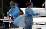 Medical personnel assist patients at a community coronavirus testing site operated in Burlington, North Carolina, July 9, 2020. (AP Photo/Gerry Broome)