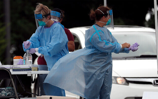 Medical personnel assist patients at a community coronavirus testing site operated in Burlington, North Carolina, July 9, 2020. (AP Photo/Gerry Broome) Medical personnel assist patients at a community coronavirus testing site operated in Burlington, North Carolina, July 9, 2020. (AP Photo/Gerry Broome)