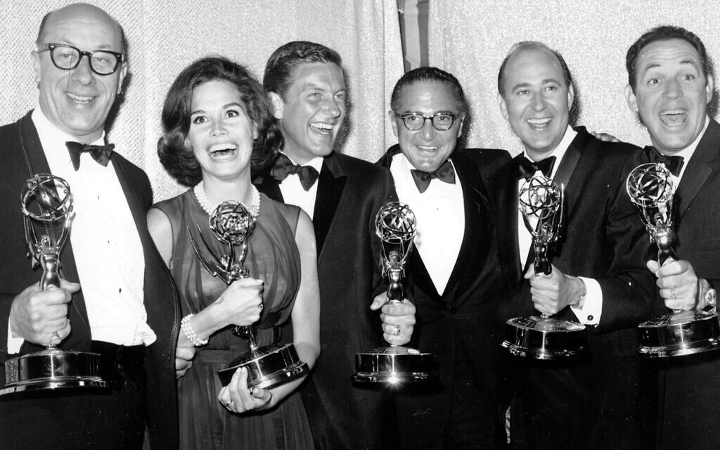 Cast and crew of the television comedy series "The Dick Van Dyke Show" from left, Richard Deacon, Mary Tyler Moore, Outstanding Continued Performance by an Actress in a Series, Lead; Dick Van Dyke, Outstanding Continued Performance by an Actor in a Series, Lead; Sheldon Leonard, producer of the show, which was named best comedy series; Carl Reiner, Outstanding Writing Achievement in a Series; and Jerry Paris, Outstanding Directorial Achievement in Comedy. pose with their awards at the 16th Annual Emmy Awards in Los Angeles, May 24, 1964. (AP Photo, File)